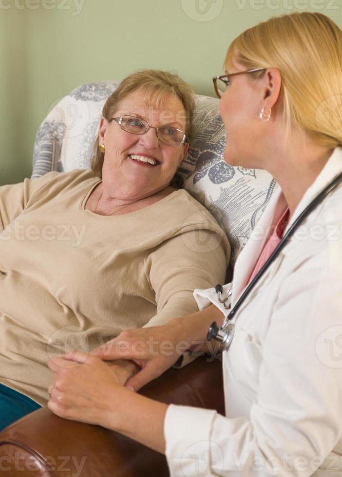 medico o infermiera parlando per seduta anziano donna foto