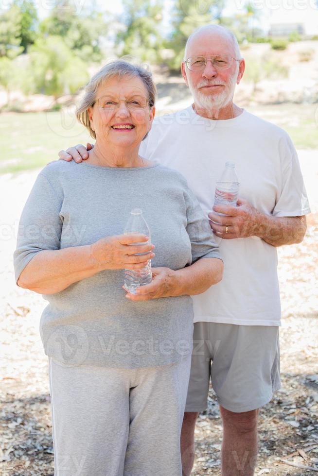 contento salutare anziano coppia con acqua bottiglie foto