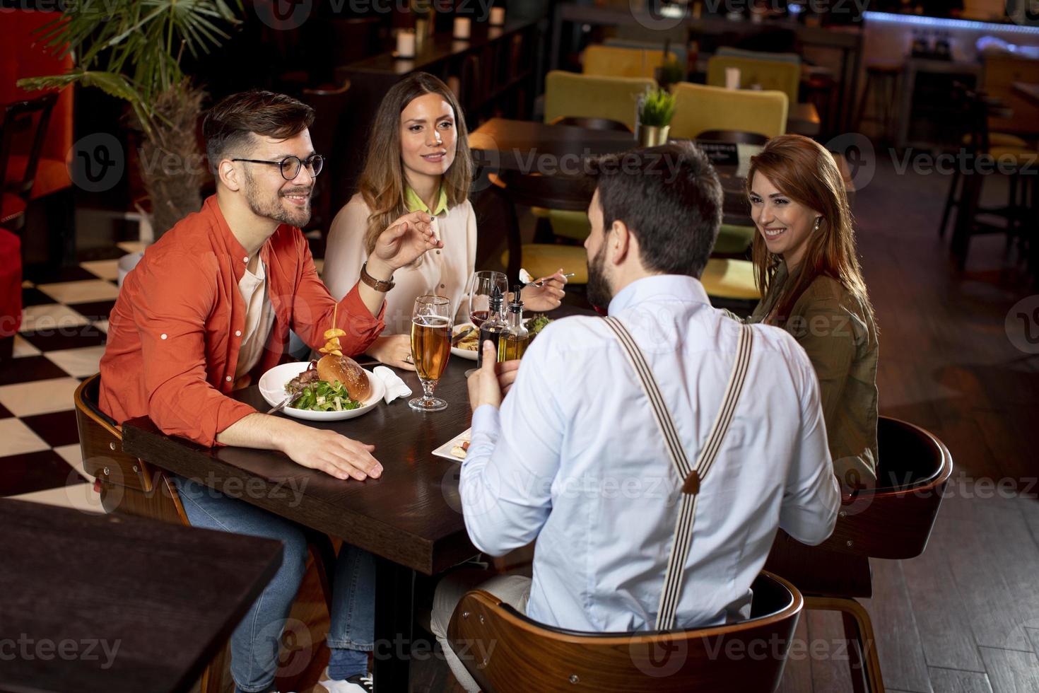 giovane persone avendo cena nel il ristorante foto