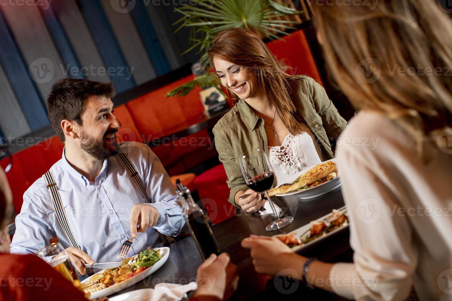 giovane persone avendo cena nel il ristorante foto