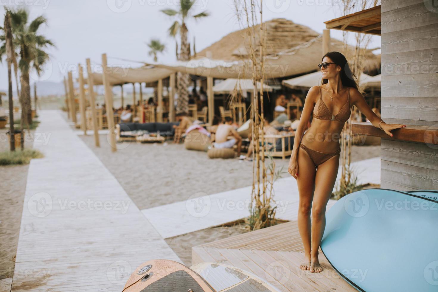 giovane donna nel bikini in piedi di il Surf cabina su un' estate giorno foto