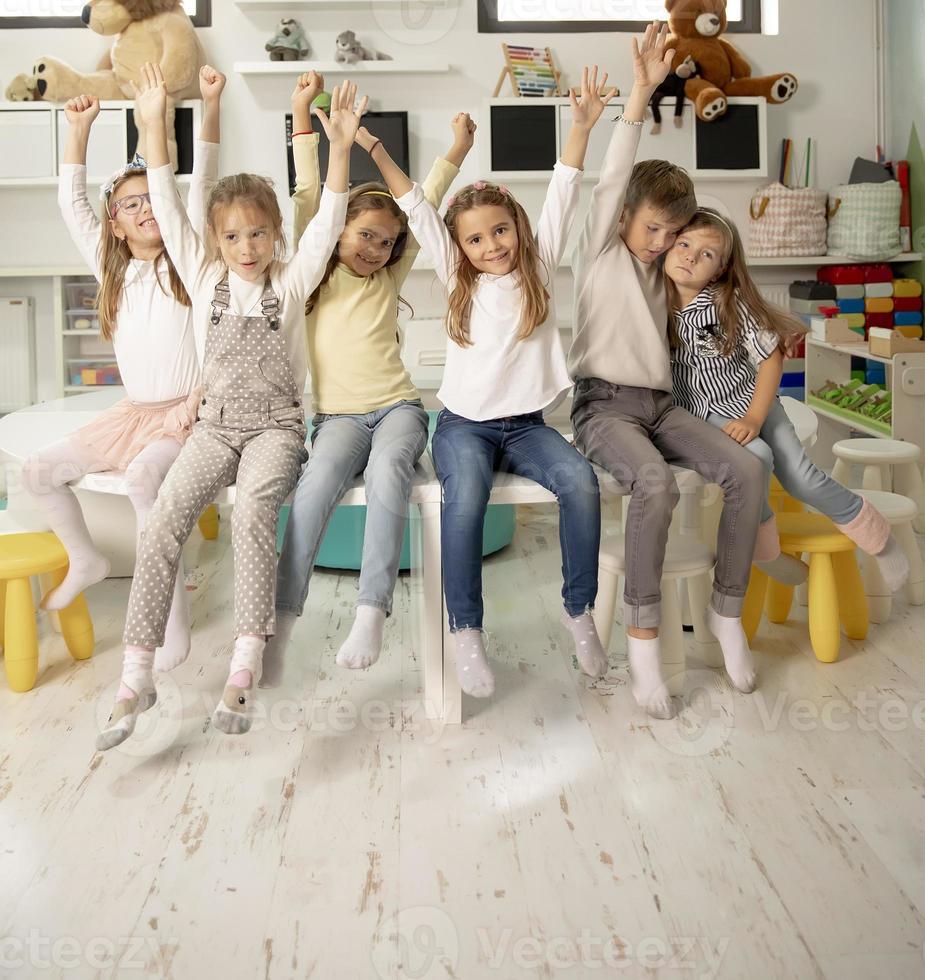 gruppo di scuola materna ragazzo amici seduta e avendo divertimento foto