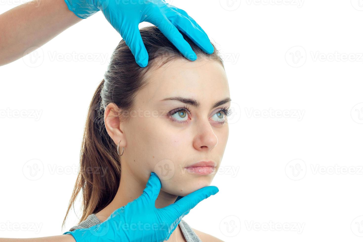 bellissimo viso grave ragazza chi visitato un' medico-cosmetologo nel blu guanti avvicinamento foto