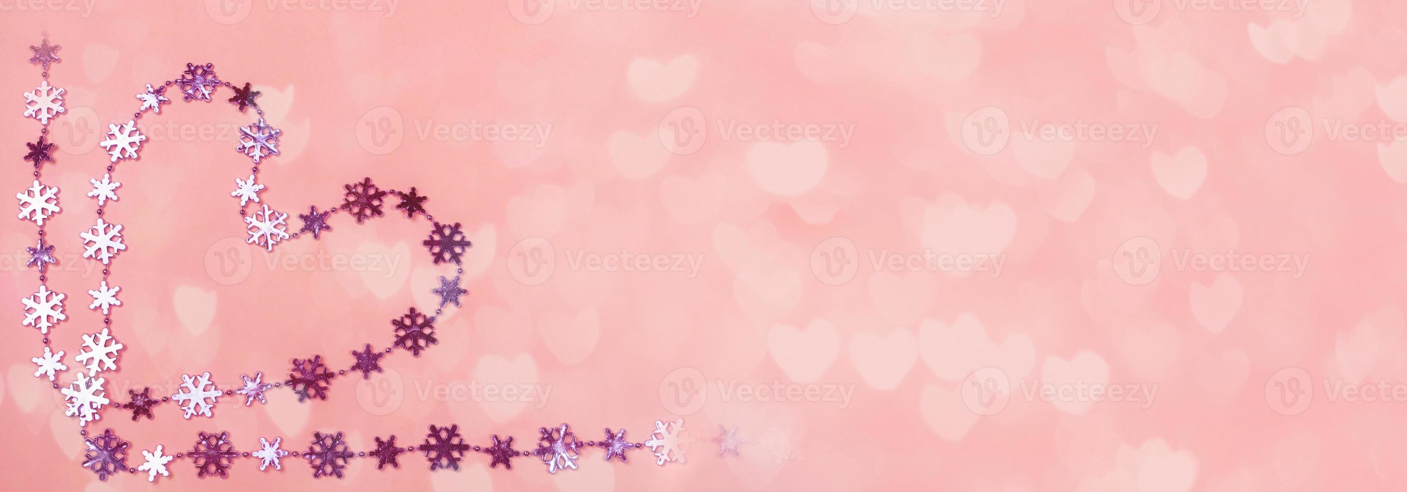 creativo San Valentino giorno striscione. cuore di brillante lilla i fiocchi di neve su dolce rosa sfondo con bokeh nel cuori forma. foto