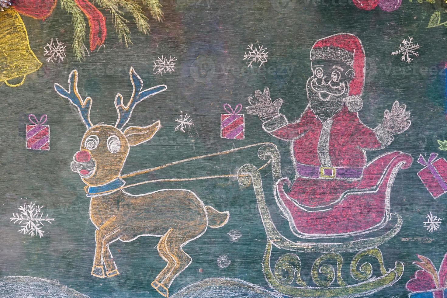 disegno di Santa Claus con renna su il lavagna dipinto con diverso colori di gesso di asiatico studenti ha disegnato decorazioni per il della scuola Natale celebrazioni. foto