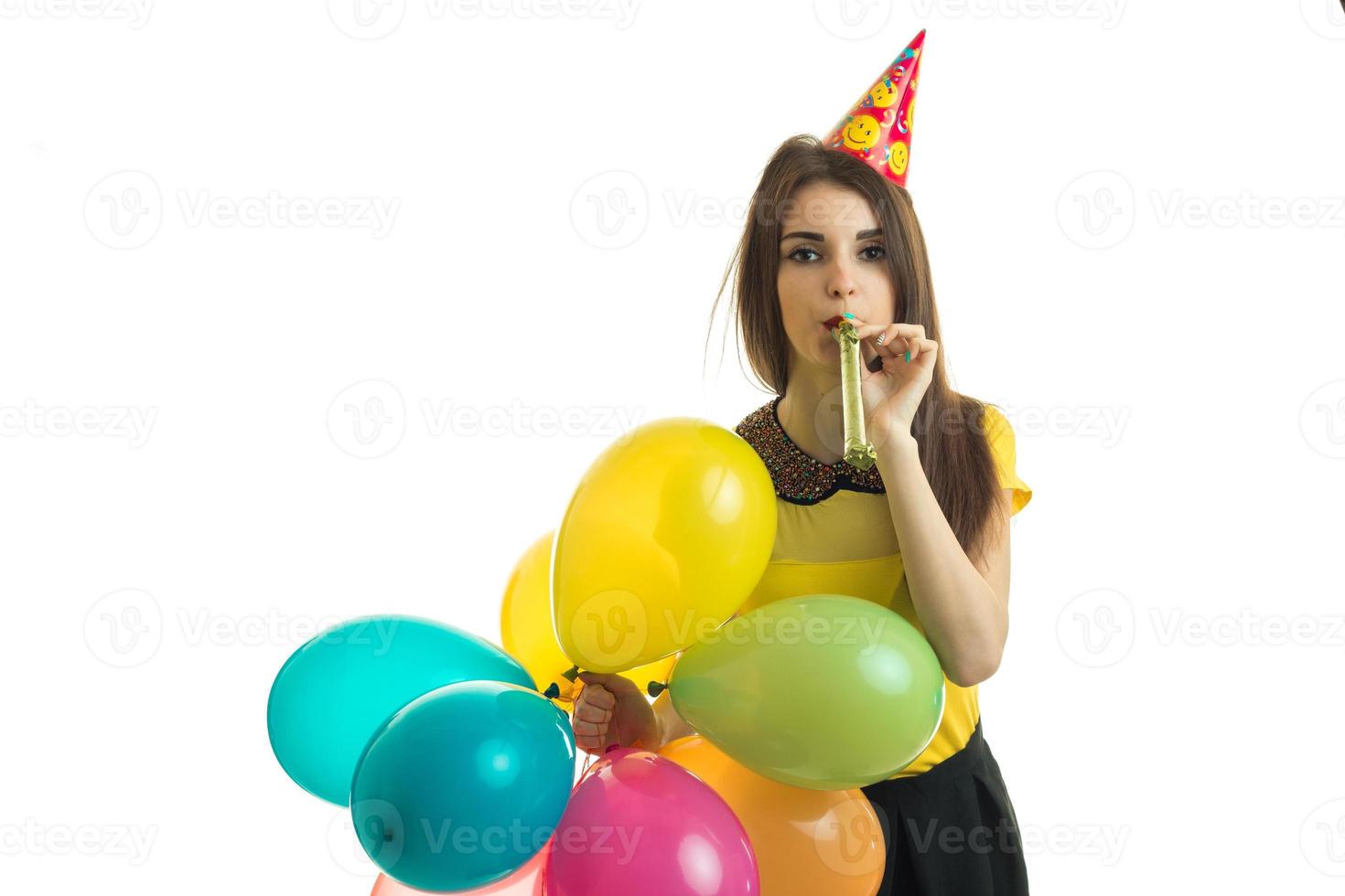 giovane elegante ragazza soffiaggio corno con palloncini nel sua mani su compleanno festa foto