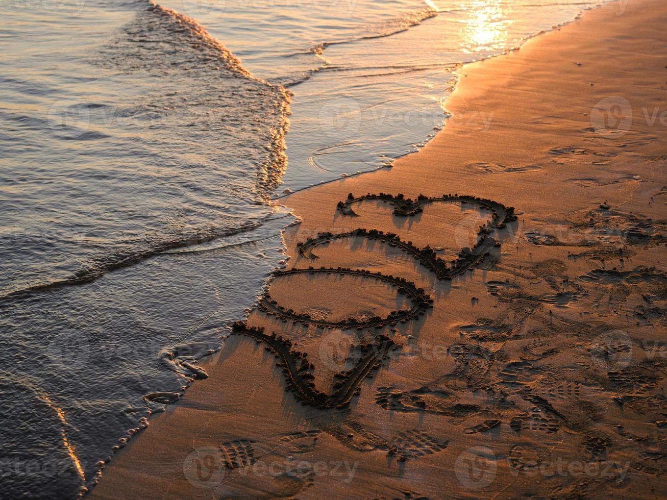 nuovo anno concetto foto. numeri 2023 manoscritto nel il sabbia superficie. morbido mare onda e spiaggia su sfondo. foto