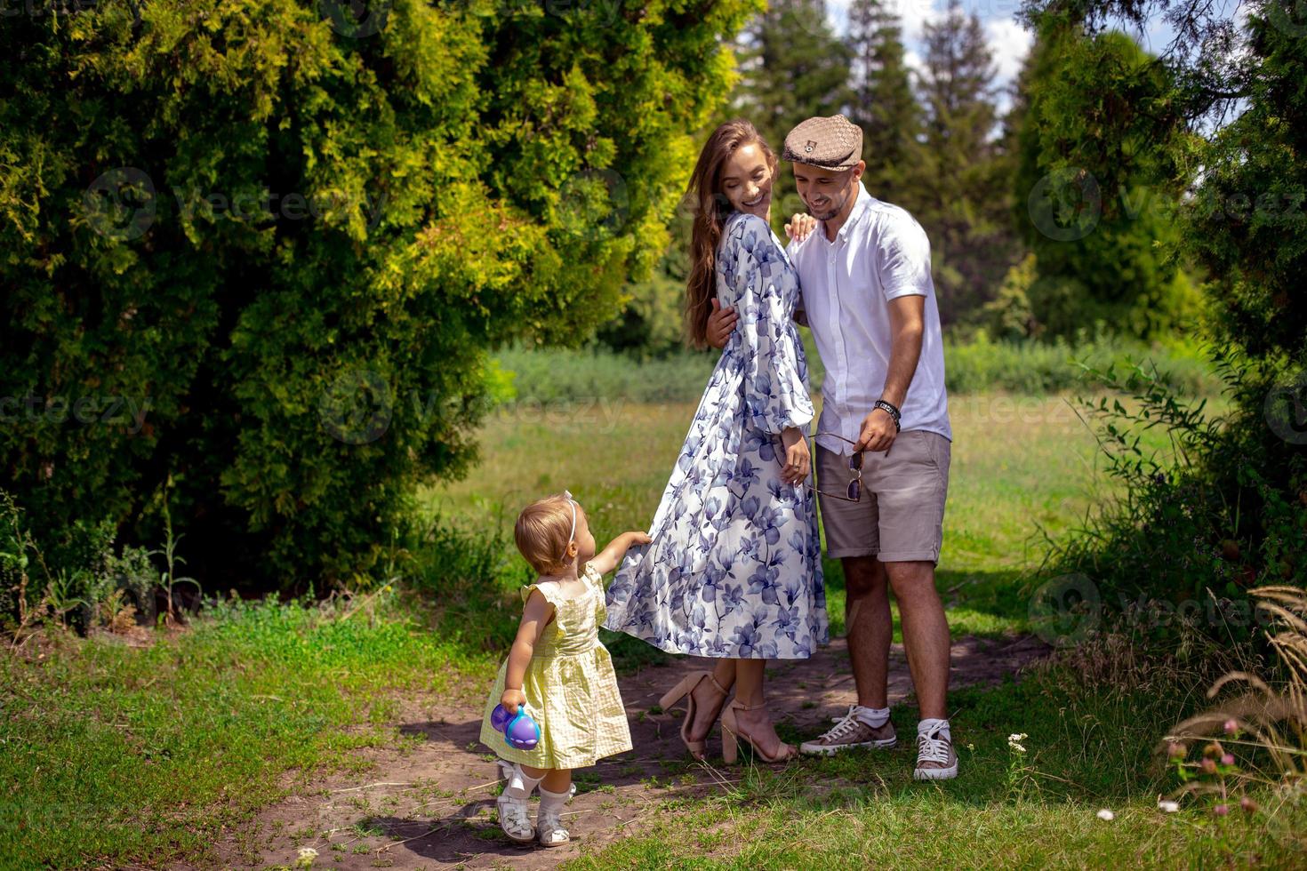 contento famiglia giochi con poco bambino figlia a il verde parco foto