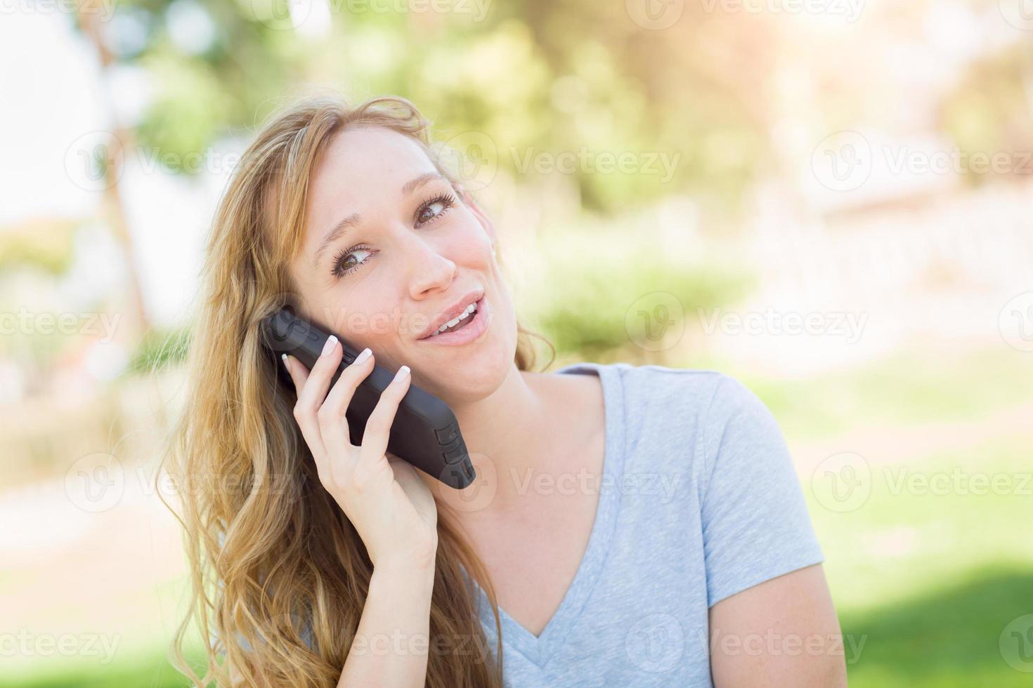 giovane adulto donna all'aperto parlando su sua inteligente Telefono. foto