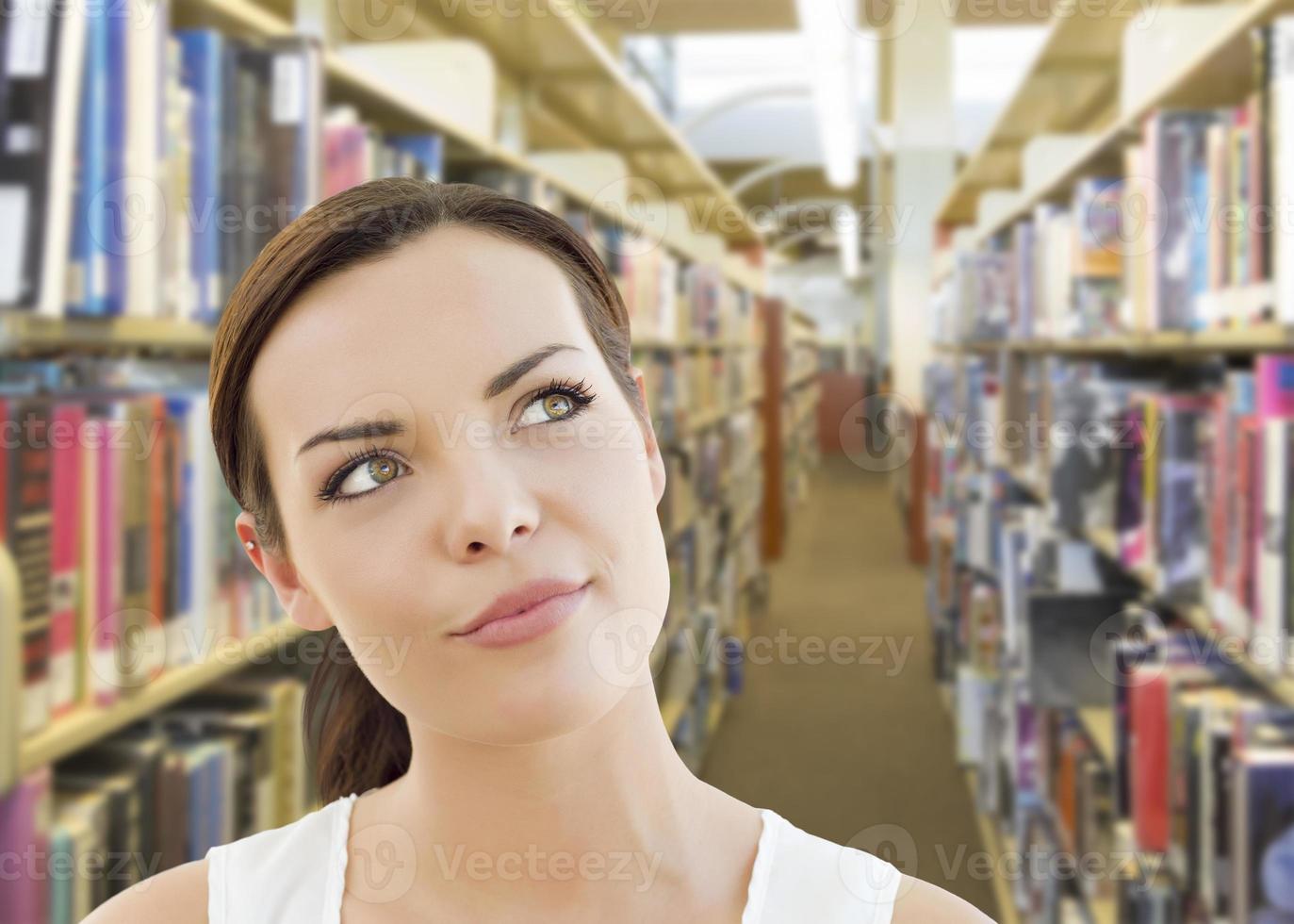 misto gara ragazza guardare per il lato nel il biblioteca foto