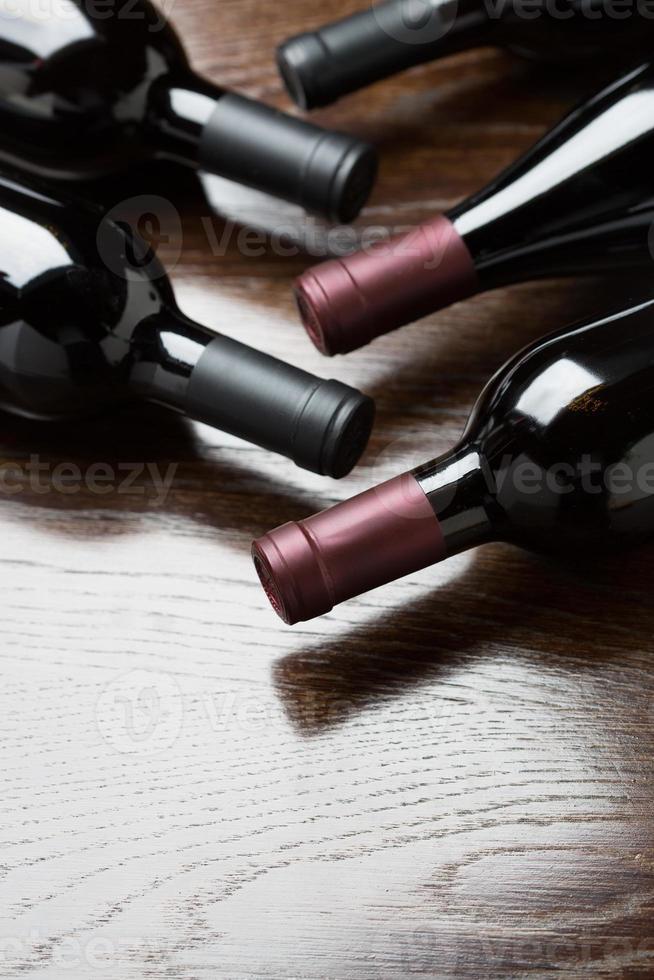 vario vino bottiglie su un' riflessivo legna superficie astratto. foto