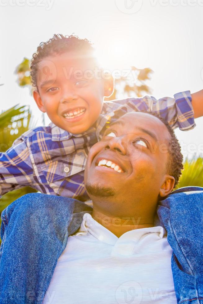 misto gara figlio e africano americano padre giocando a cavalluccio all'aperto insieme. foto