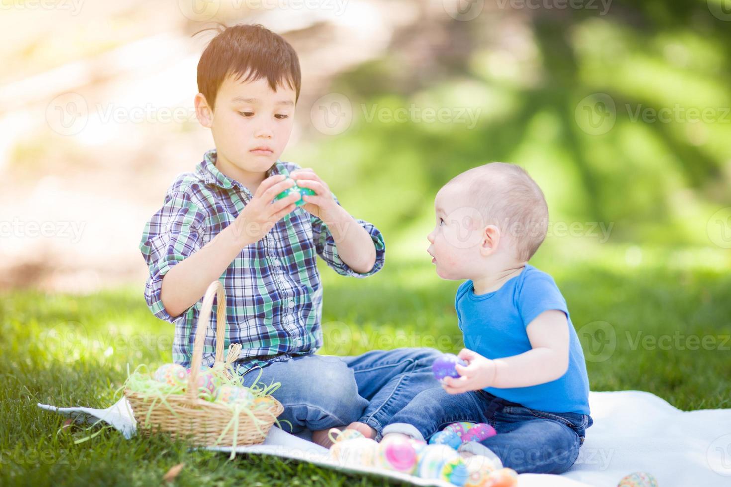 misto gara Cinese e caucasico ragazzi al di fuori nel parco giocando con Pasqua uova foto