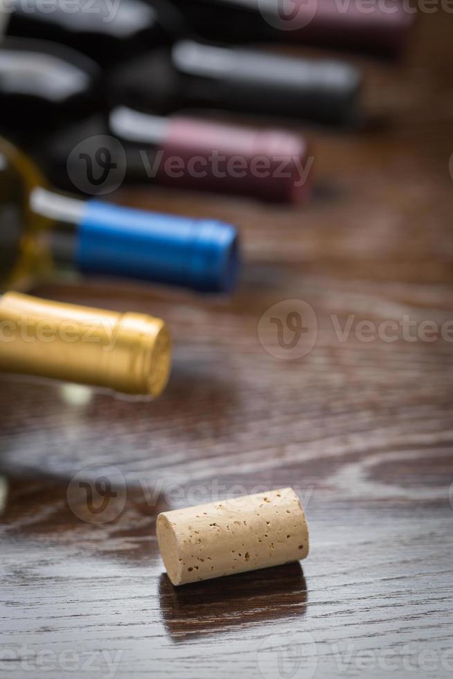 vino bottiglie e sughero su un' riflessivo legna superficie astratto. foto