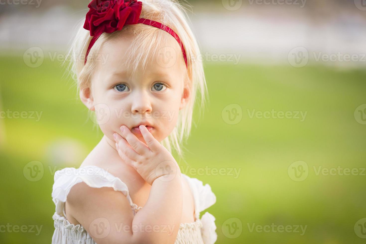 adorabile poco ragazza indossare bianca vestito nel un' erba campo foto