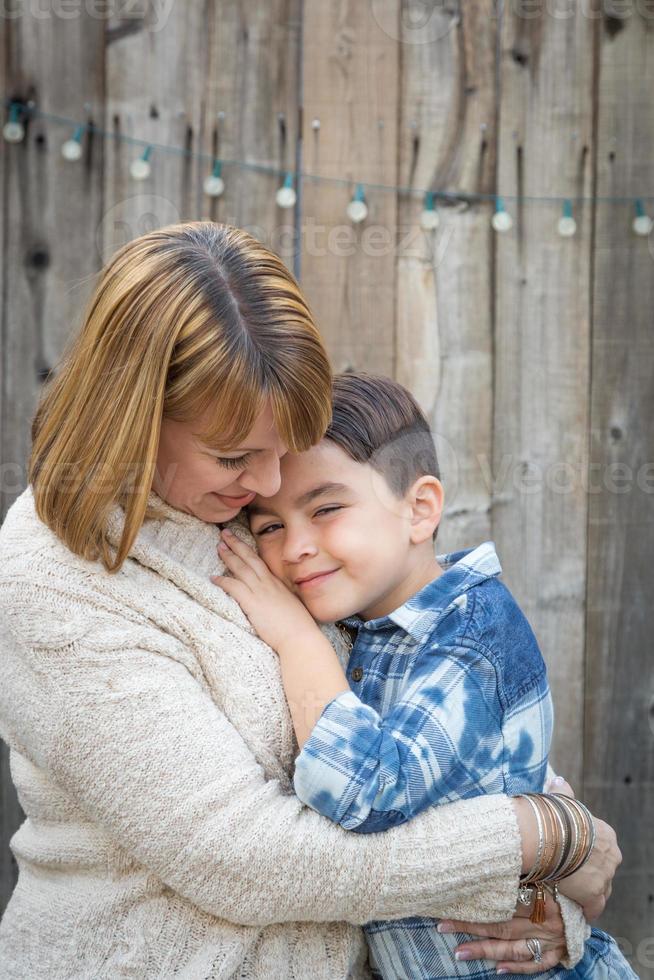 madre e misto gara figlio abbraccio vicino recinto foto