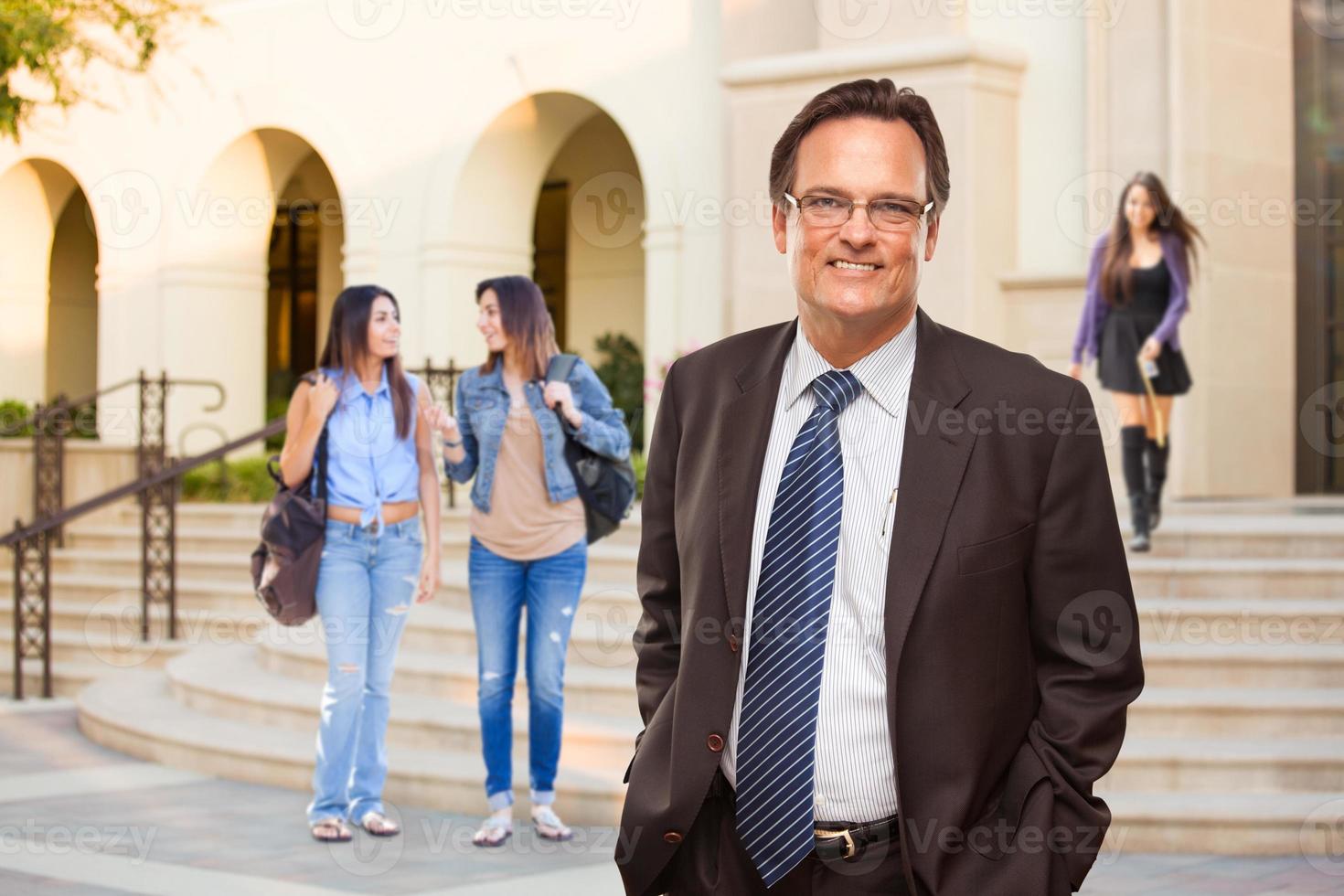 maschio adulto amministratore nel completo da uomo e cravatta a piedi su città universitaria foto