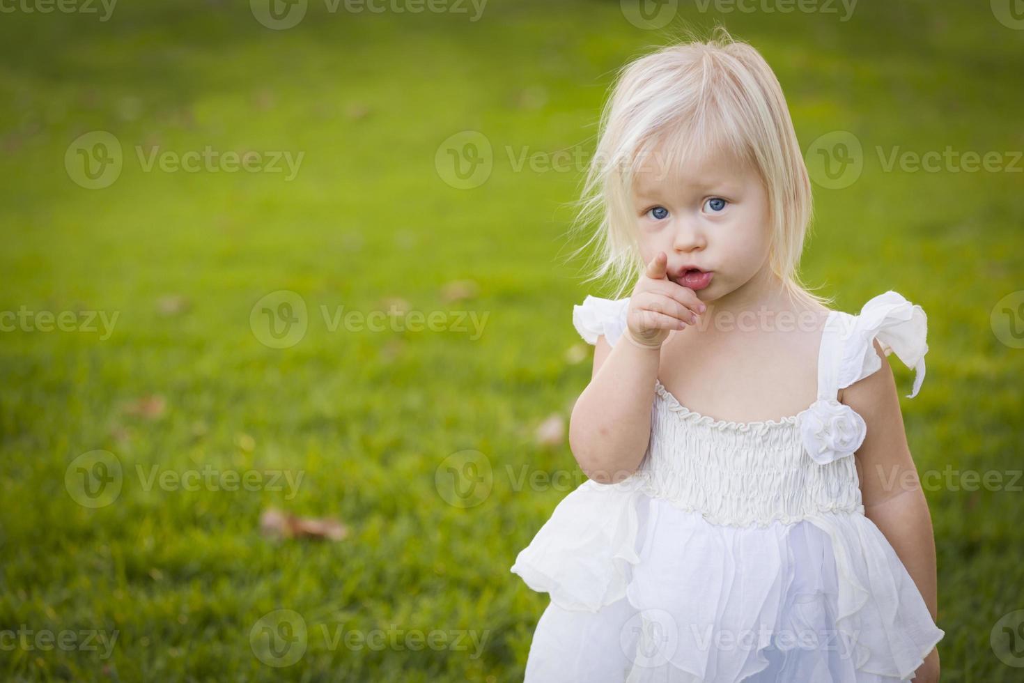 adorabile poco ragazza indossare bianca vestito nel un' erba campo foto