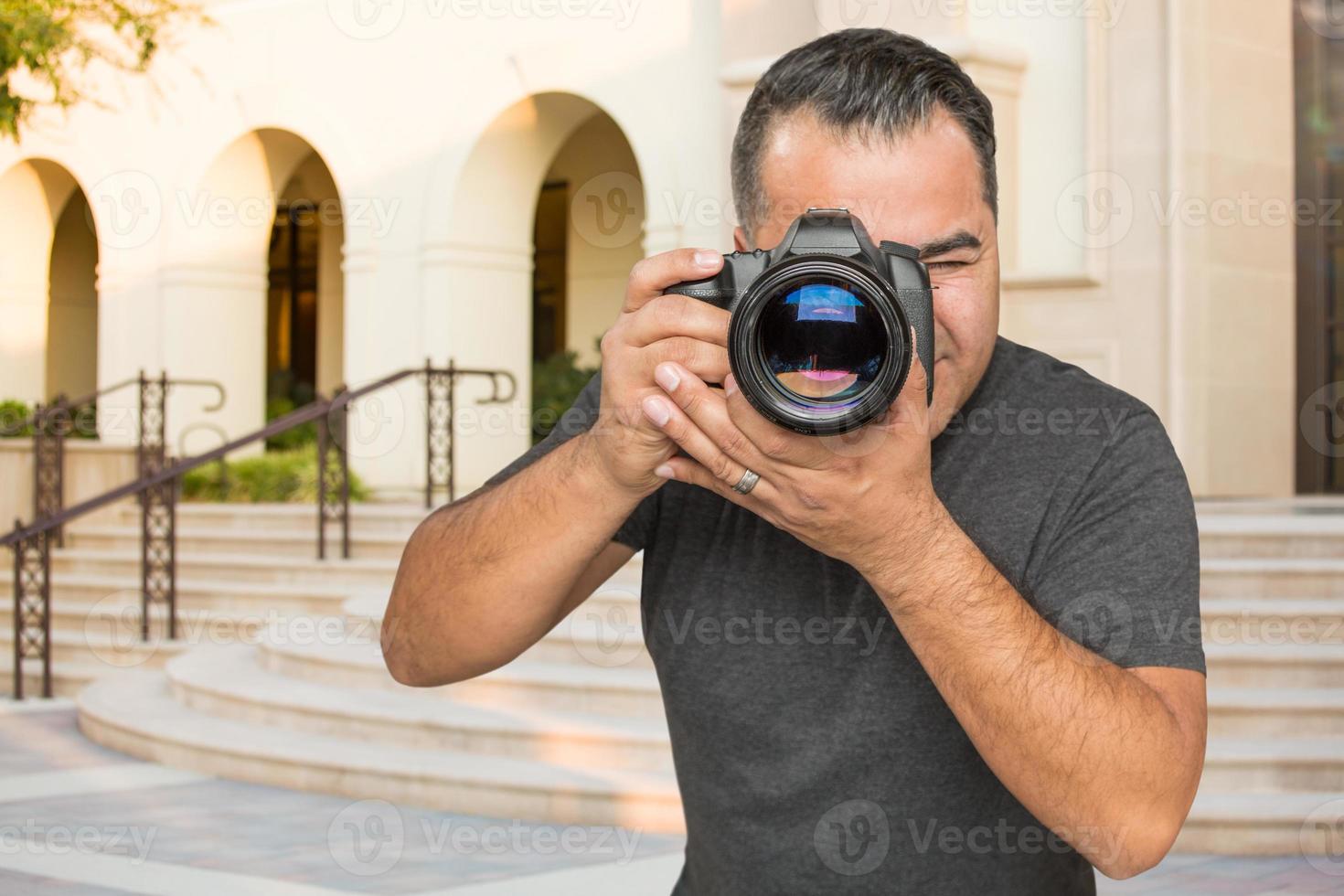 ispanico giovane maschio fotografo con dslr telecamera all'aperto foto