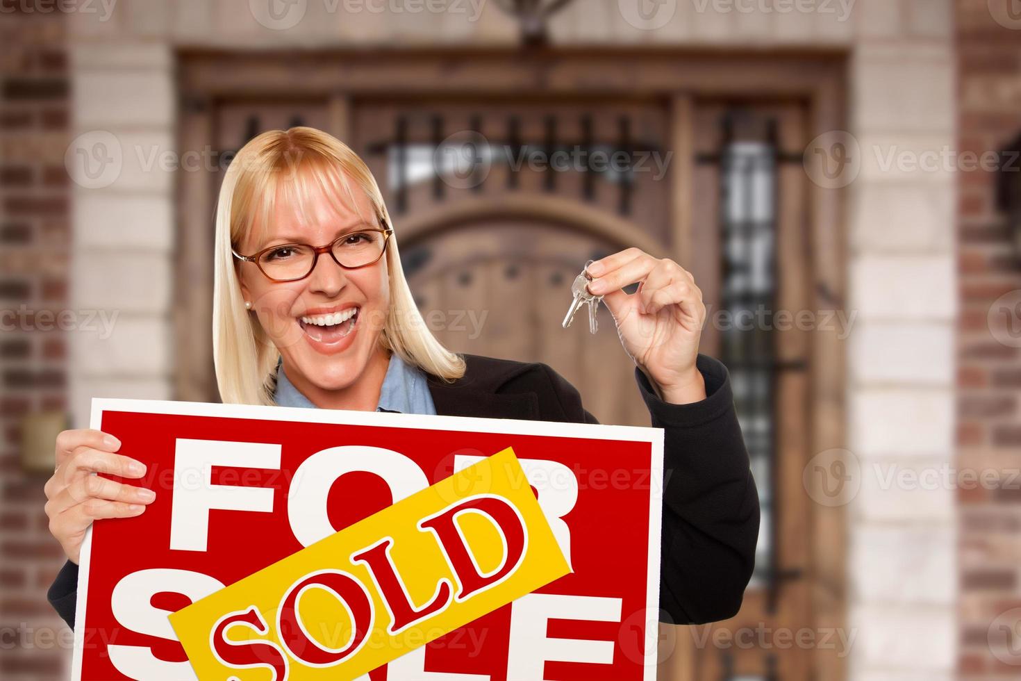 eccitato donna Tenere Casa chiavi e venduto vero tenuta cartello nel davanti di simpatico nuovo casa foto