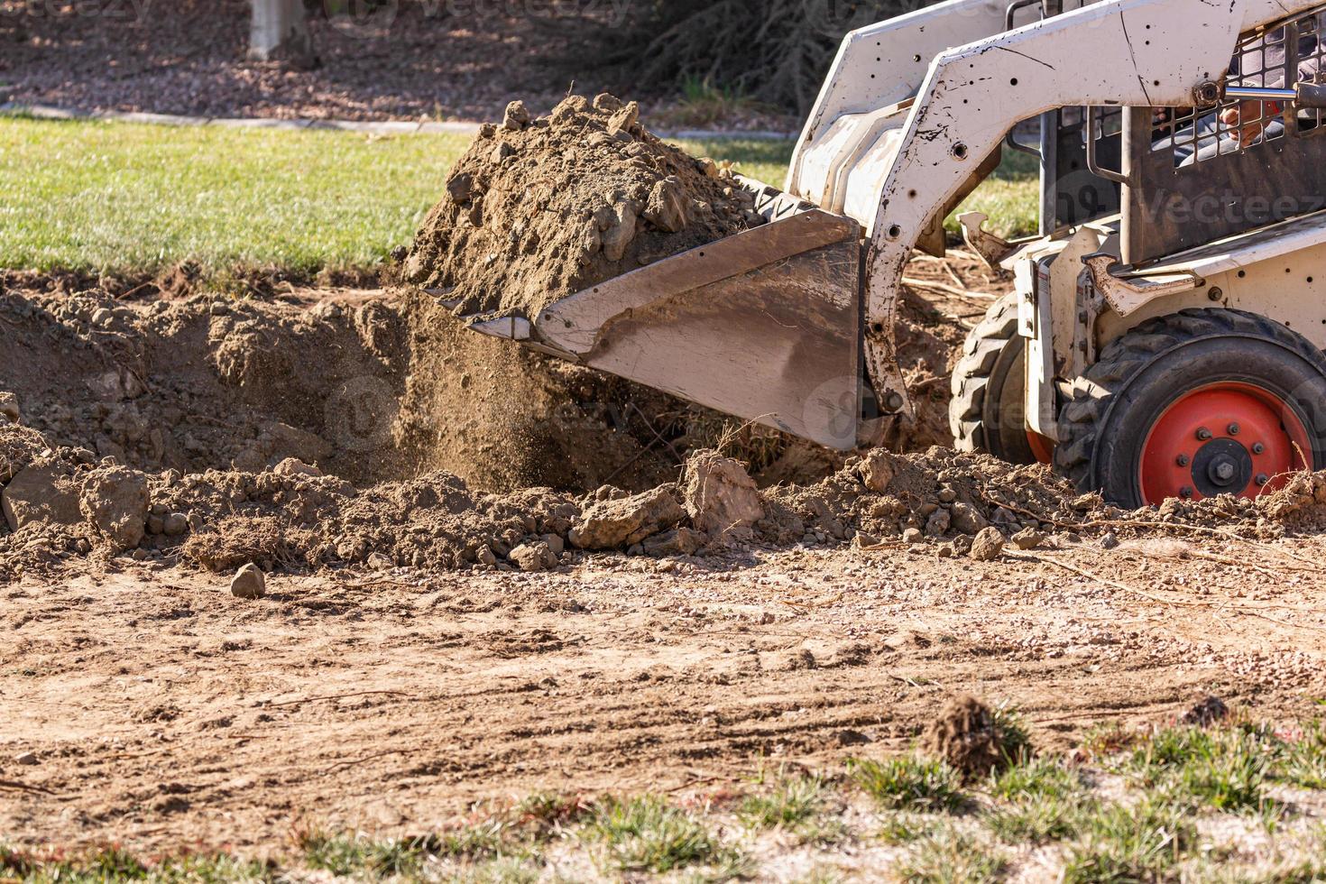 piccolo bulldozer scavando nel cortile per piscina installazione foto