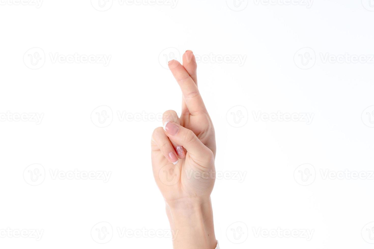 femmina mano mostrando il gesto con sollevato su e attraversato Due dita è isolato su un' bianca sfondo foto