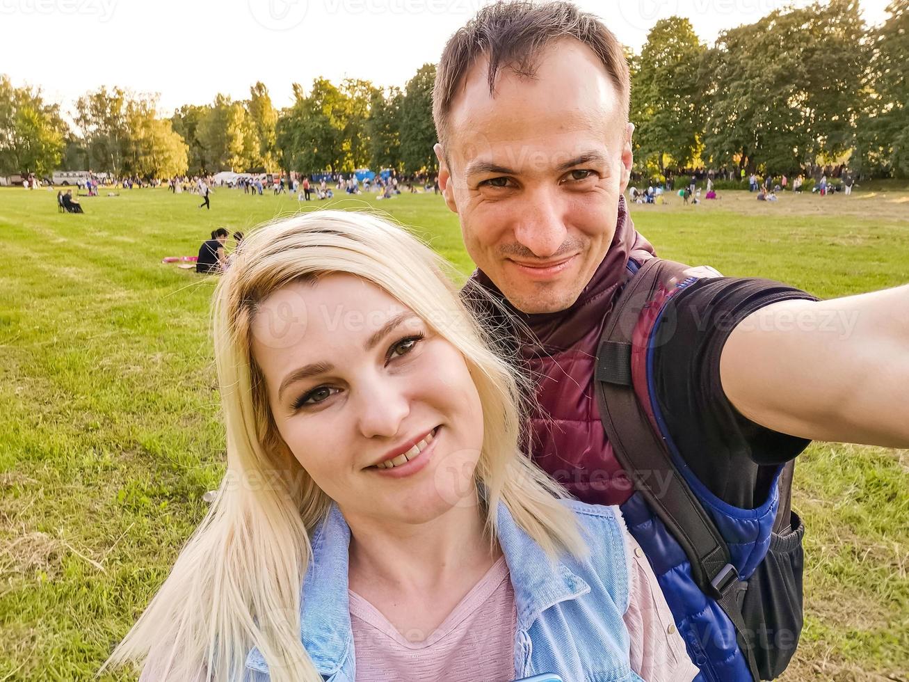 contento giovane coppia abbracciare. uomo e donna fabbricazione selfie isolato su verde sfondo foto