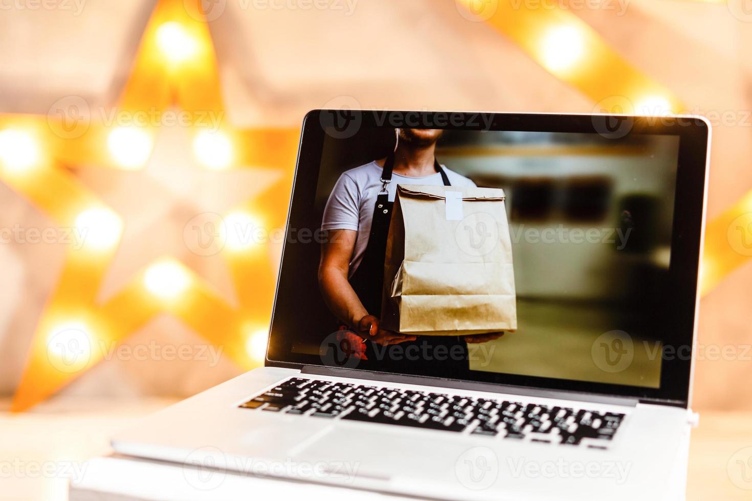 cibo consegna cibo il computer portatile su tavolo. caldo tono foto