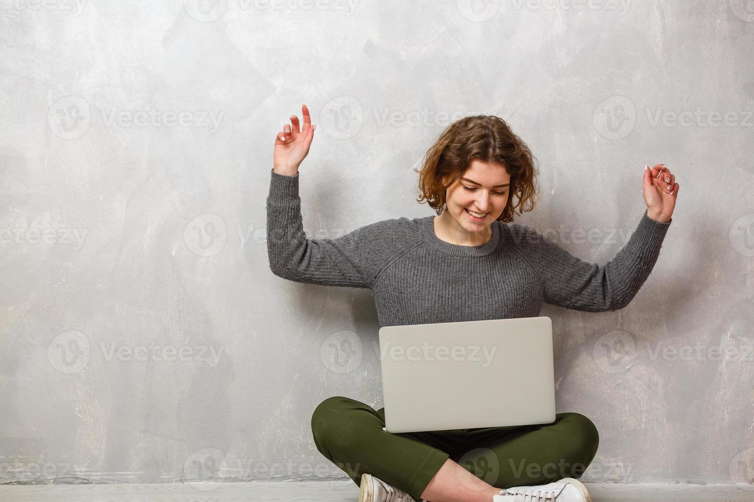 sorridente donna è puntamento su il computer portatile sfondo foto