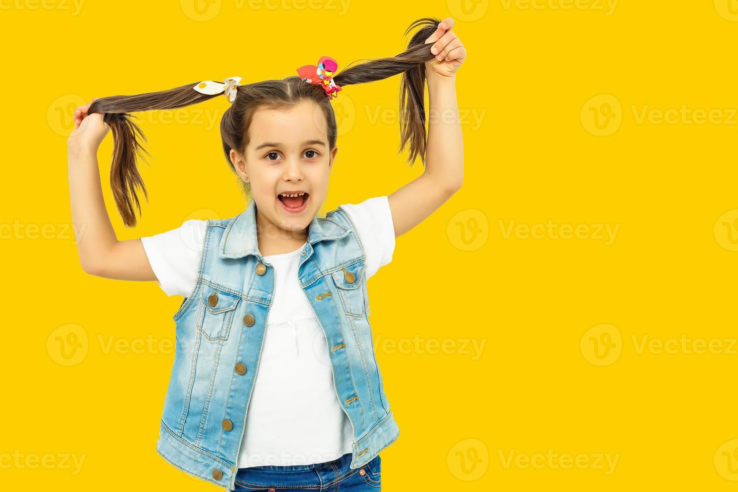 contento cinque anno vecchio ragazza nel luminosa gioia al di sopra di giallo sfondo. contento infanzia. copia spazio. foto