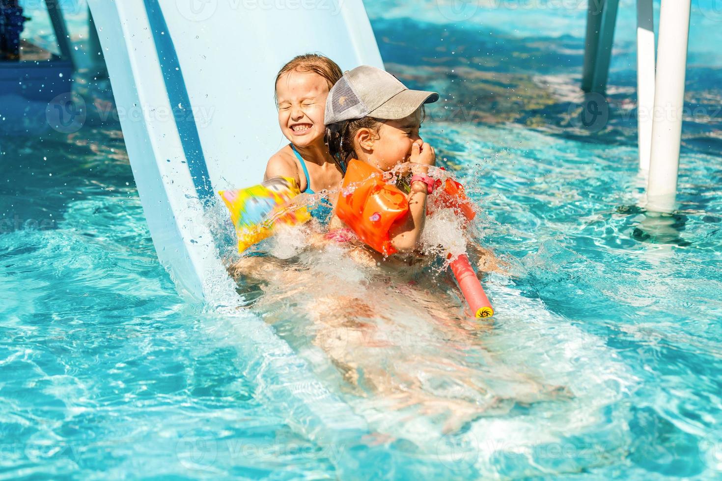 bambino su acqua diapositiva a Parco acquatico. estate vacanza. foto