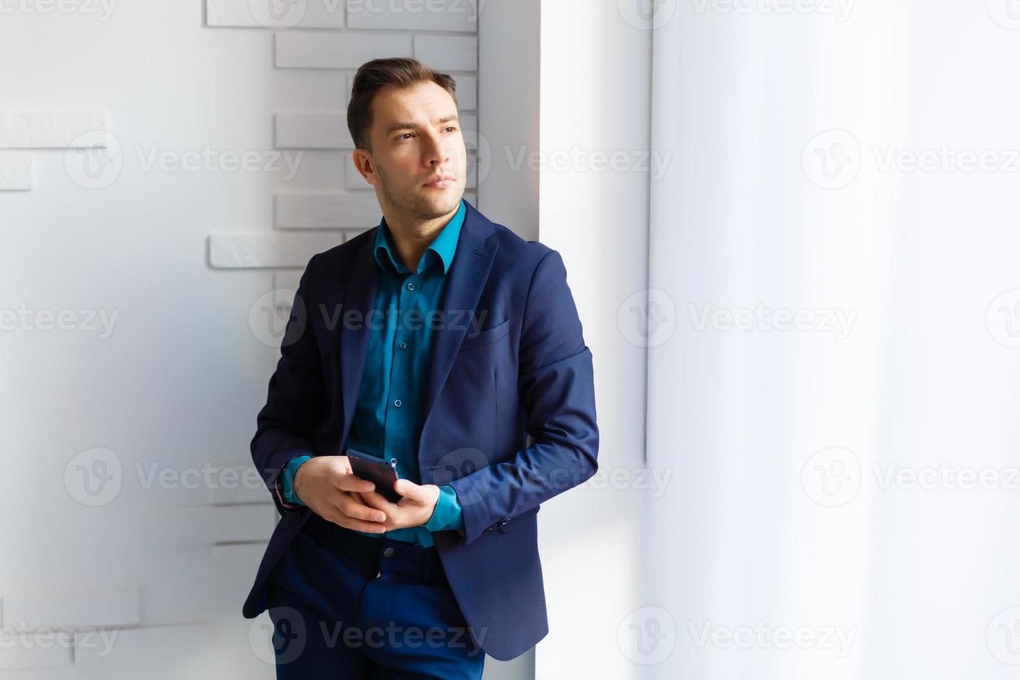 ritratto di un' giovane uomo in piedi di pacchi nel vuoto ufficio foto
