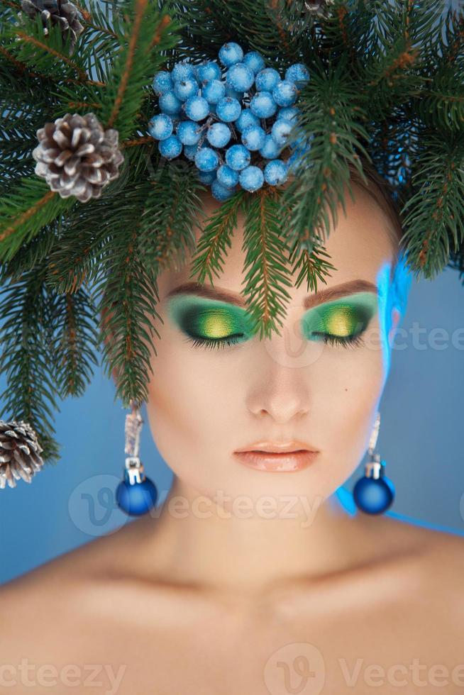 carino giovane donna con natale ghirlanda di alberi su testa e simpatico trucco foto