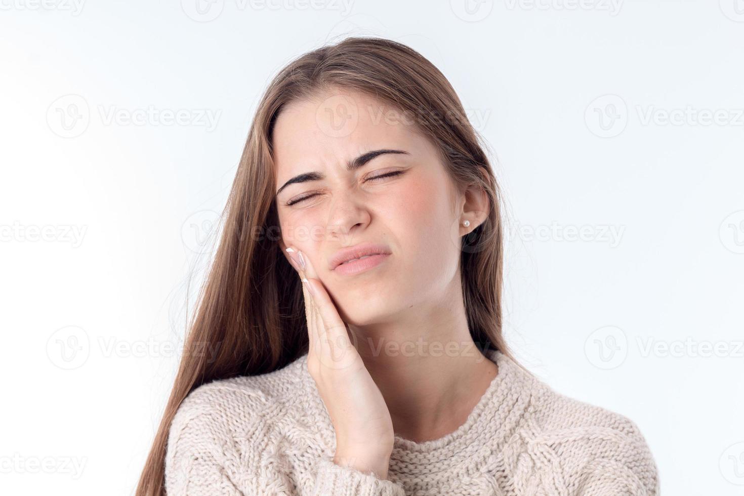 giovane ragazza si sente mal di denti e mantiene mano su il guancia dopo chiusura il occhi è isolato bianca sfondo foto