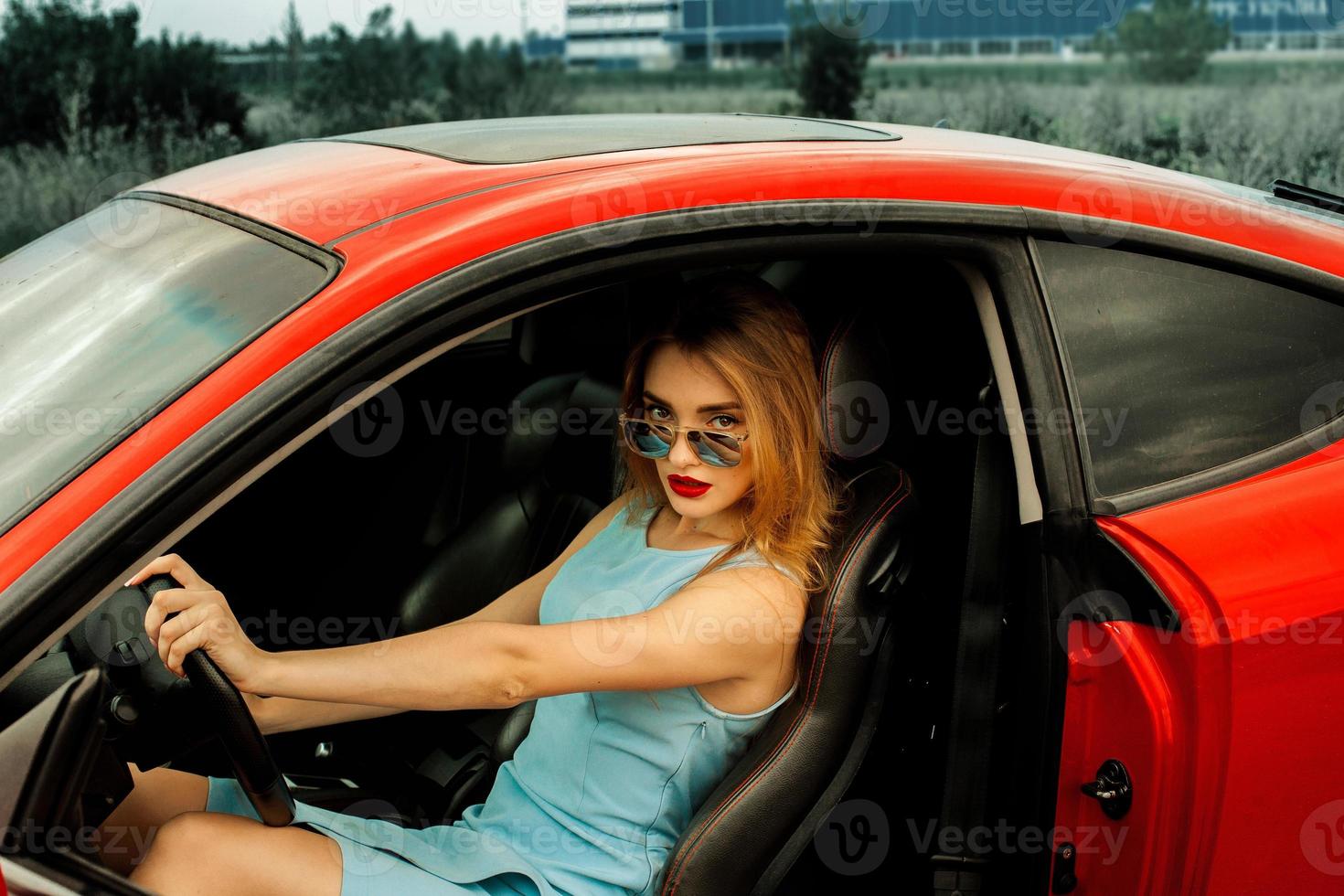 bellissimo giovane signora nel rosso auto foto