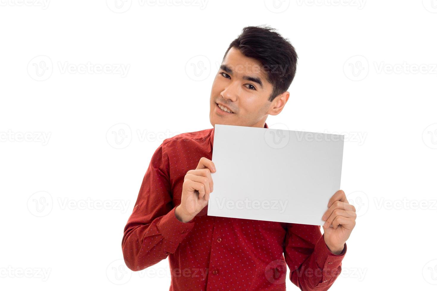 ritratto di alla moda giovane uomo nel rosso maglietta con vuoto cartellone nel il suo mani isolato su bianca sfondo foto