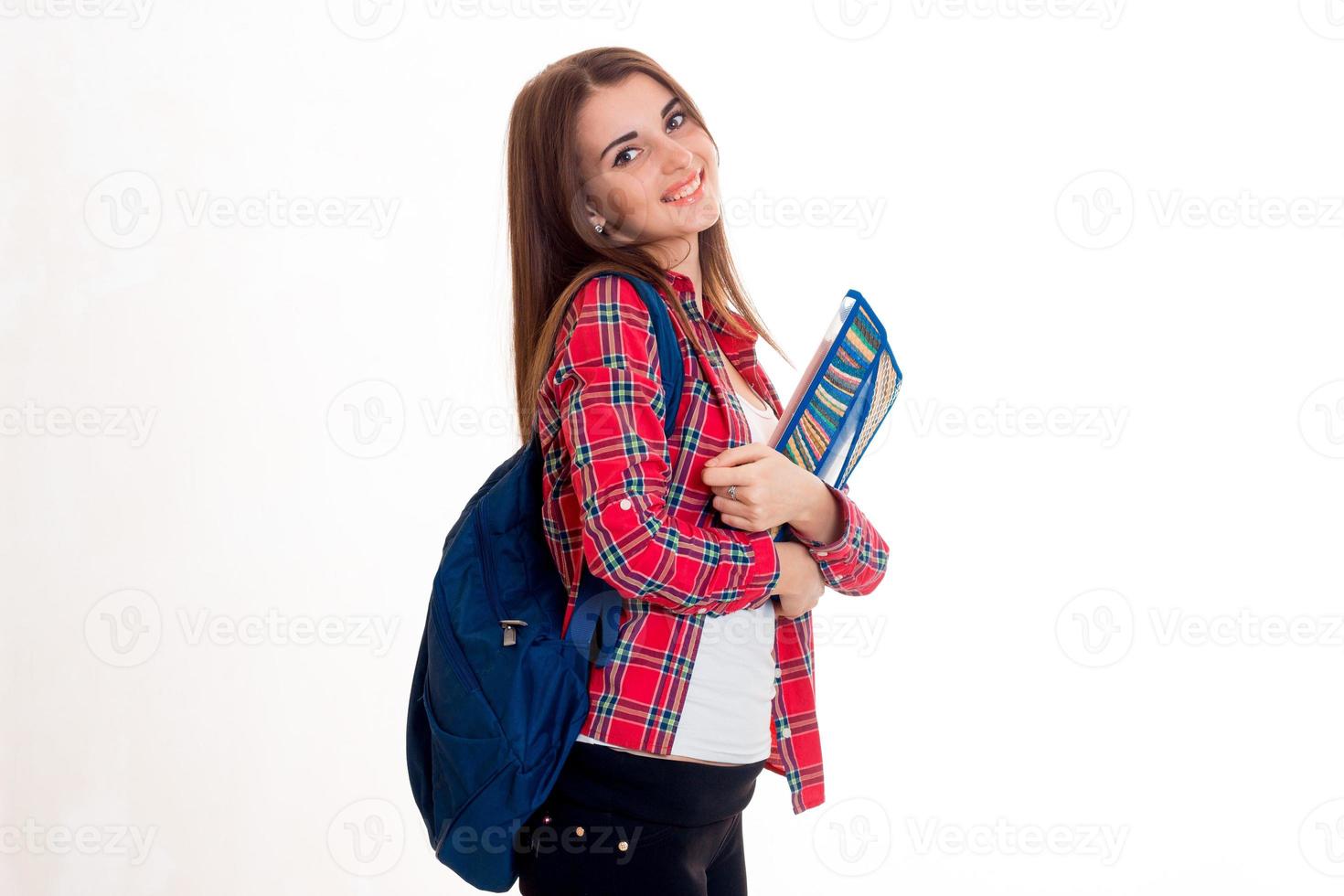 giovane carino ragazza nel un' plaid camicia e con un' ventiquattrore su il indietro sorridente e Tenere un' cartella foto