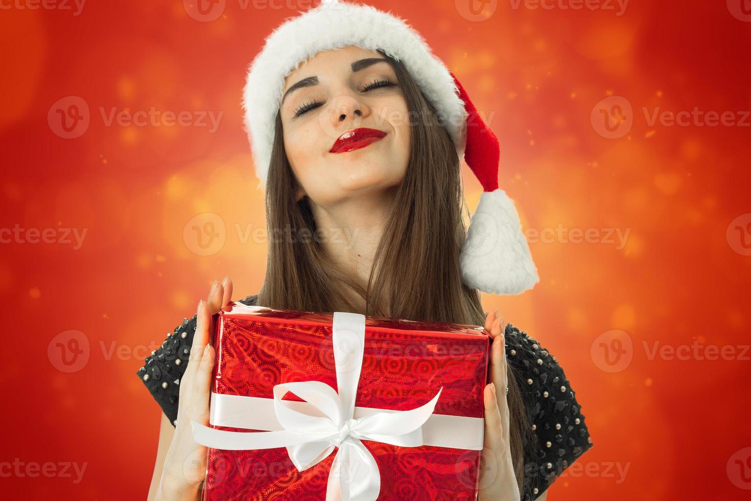 ragazza nel Santa cappello sorridente con chiuso occhi foto