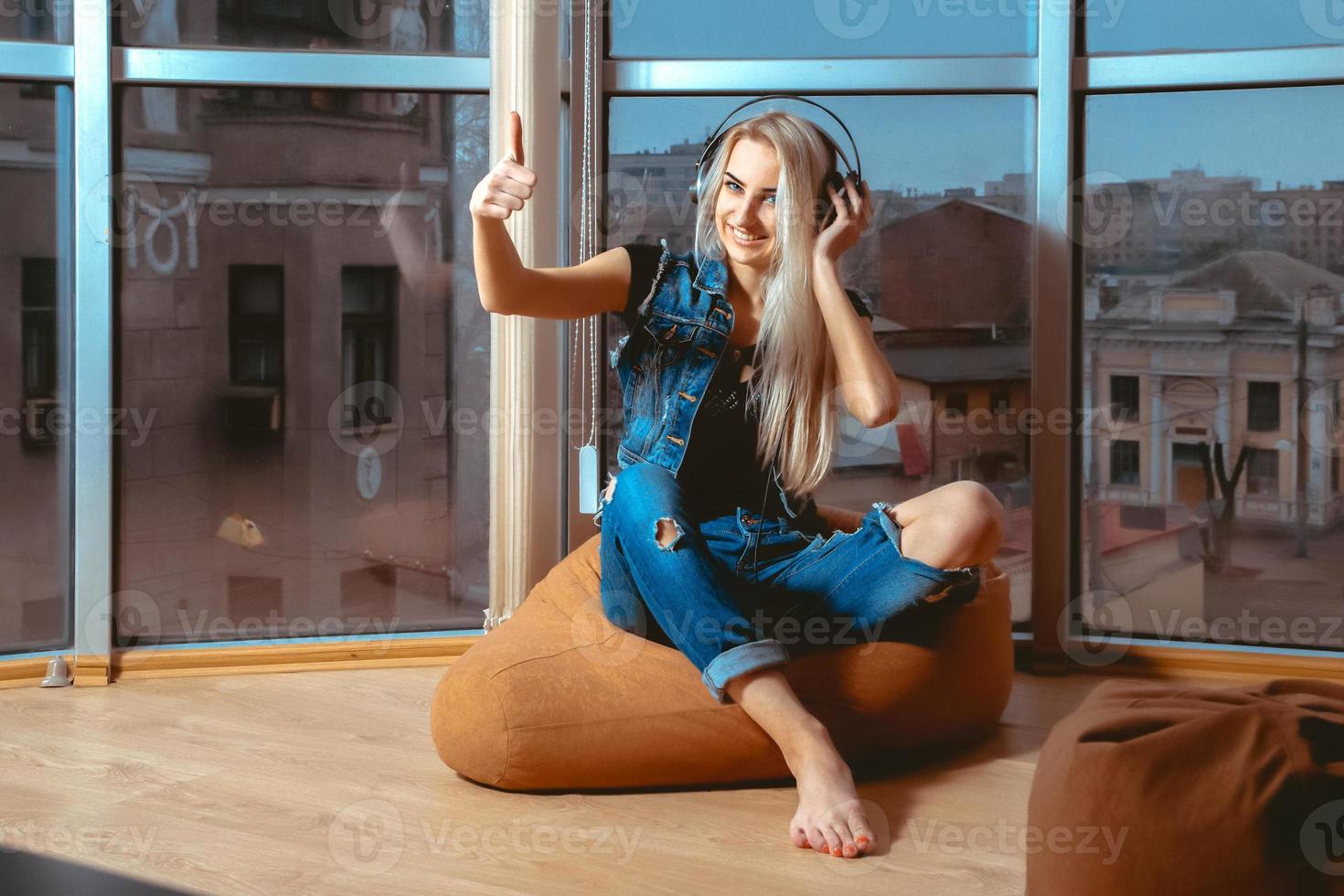 gioioso giovane bionda donna ascoltando per il musica nel cuffie foto