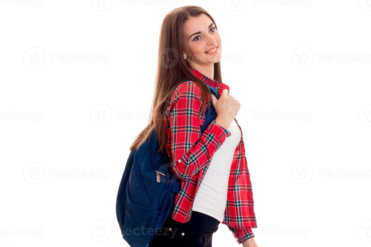 allegro giovane alunno ragazza con zaino guardare lontano e sorridente isolato su bianca sfondo. alunno anni concetto. studia concetto. foto