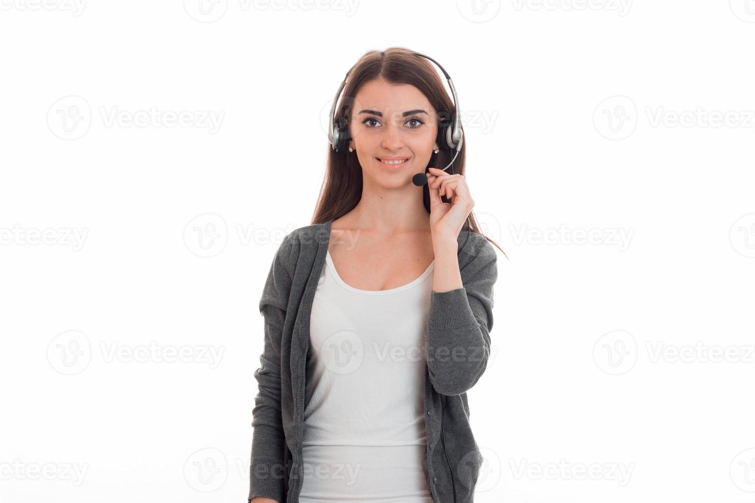 giovane attraente attività commerciale signora con cuffie e microfono nel uniforme guardare a il telecamera e sorridente isolato su bianca sfondo foto