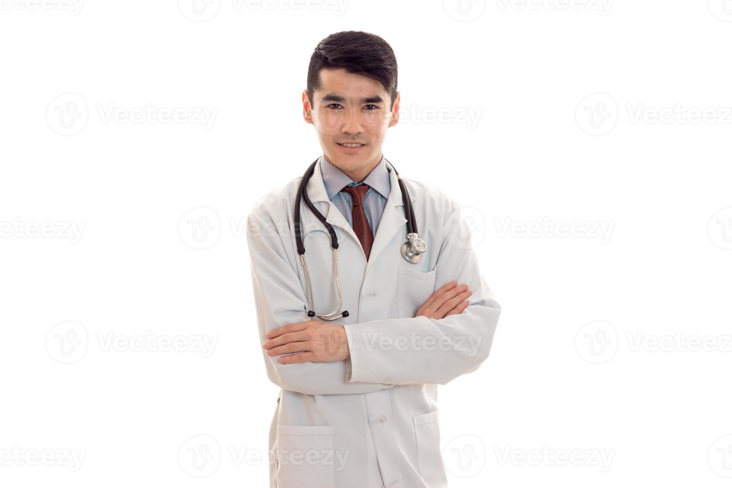 un' giovane medico con stetoscopio e bianca cappotto guardare a telecamera foto