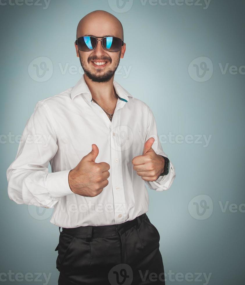 divertimento uomo nel occhiali da sole e bianca camicia nel studio sorridente foto