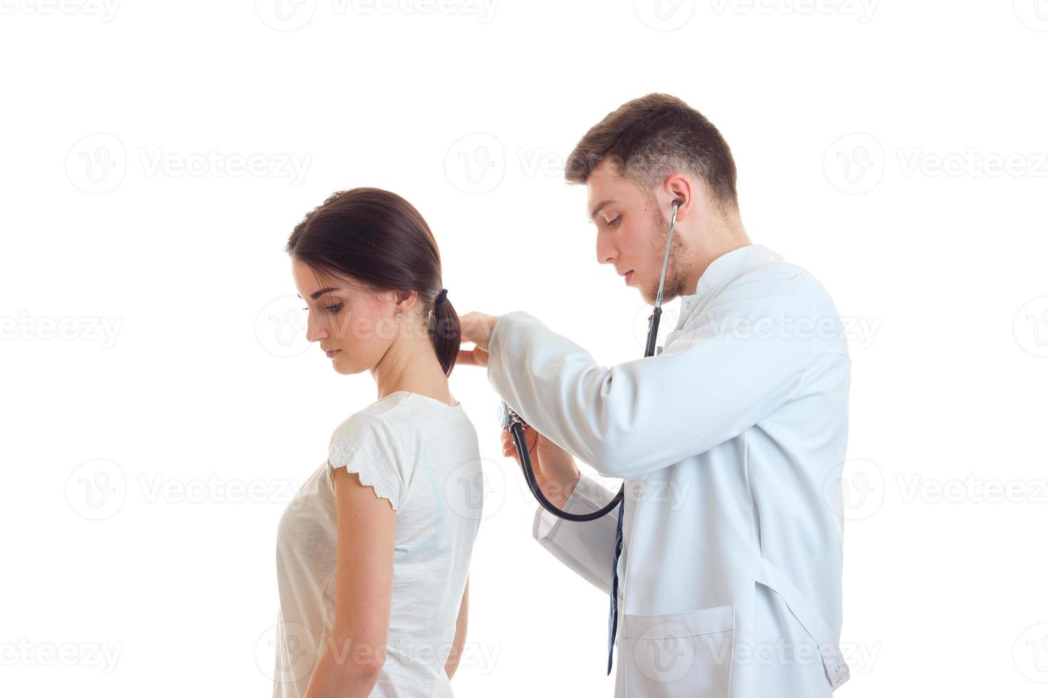 medico con stetoscopio esamina un' donna paziente foto