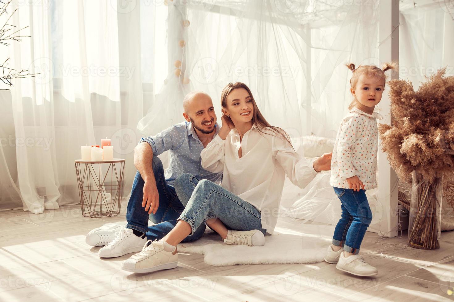 giovane famiglia a casa nel lgh Camera da letto con loro figlia foto