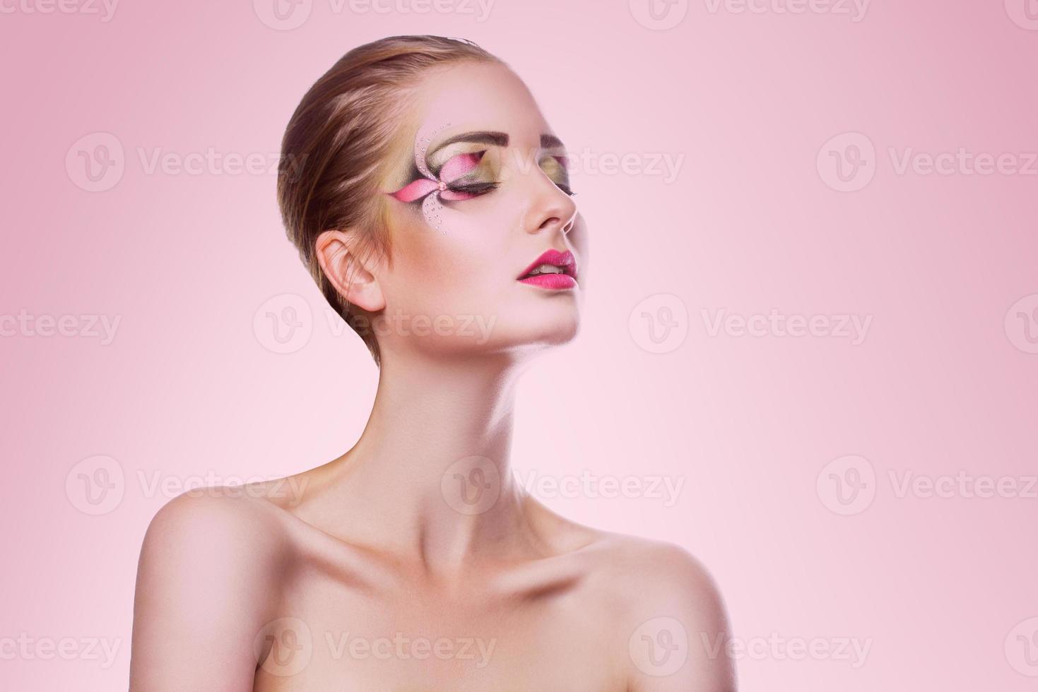 ritratto di bellezza adulto donna con creativo professionale rendere su su rosa sfondo foto