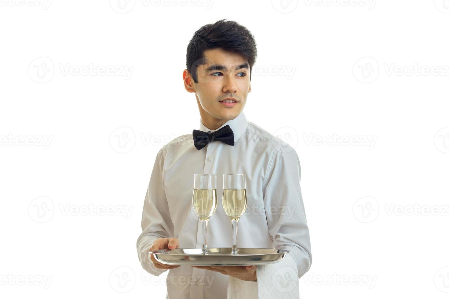 carino giovane Cameriere sta svitando mio testa per il lato e Tenere un' vassoio con bicchieri di Champagne foto