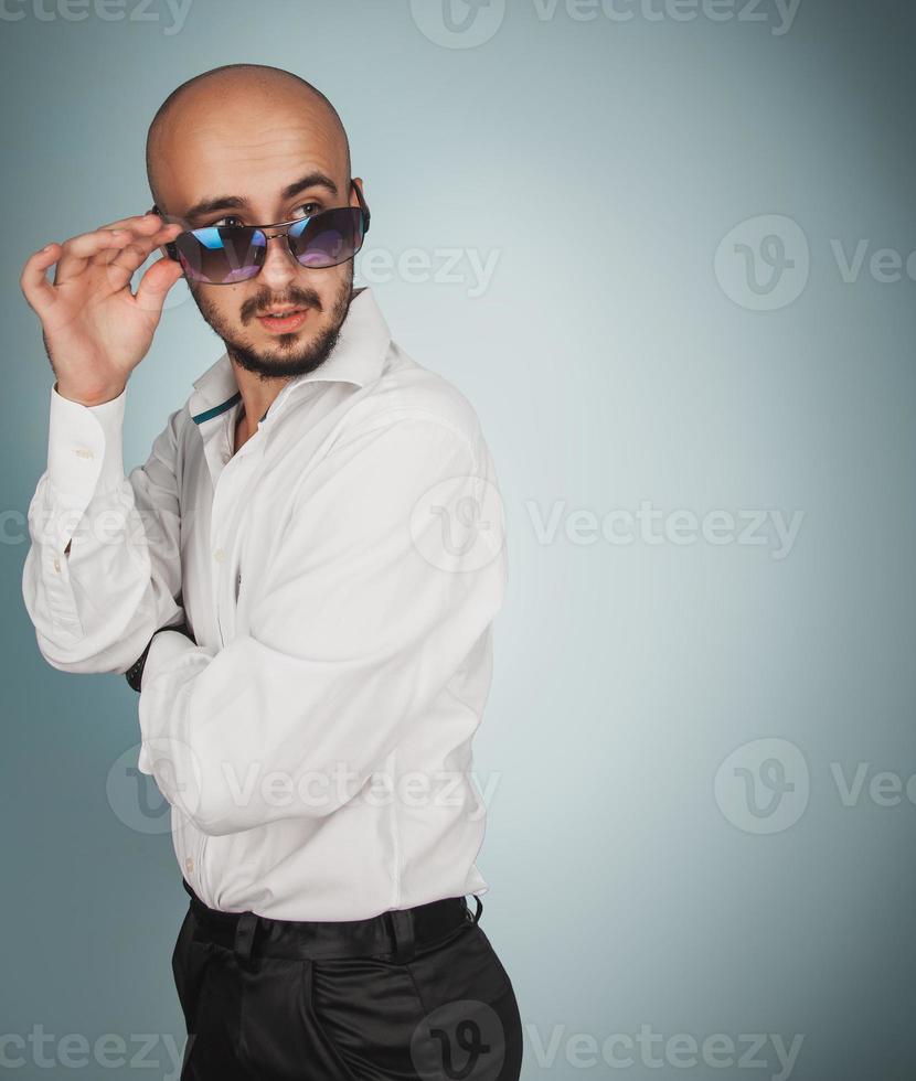 carino uomo nel occhiali da sole con barba guardare lontano foto