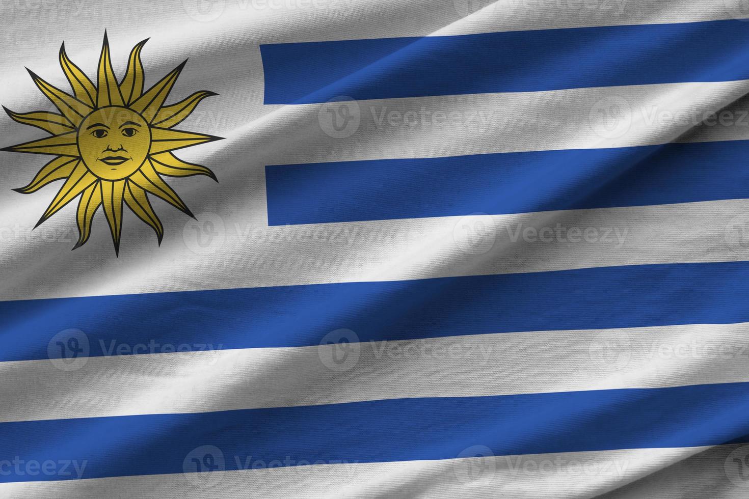 Uruguay bandiera con grande pieghe agitando vicino su sotto il studio leggero al chiuso. il ufficiale simboli e colori nel bandiera foto