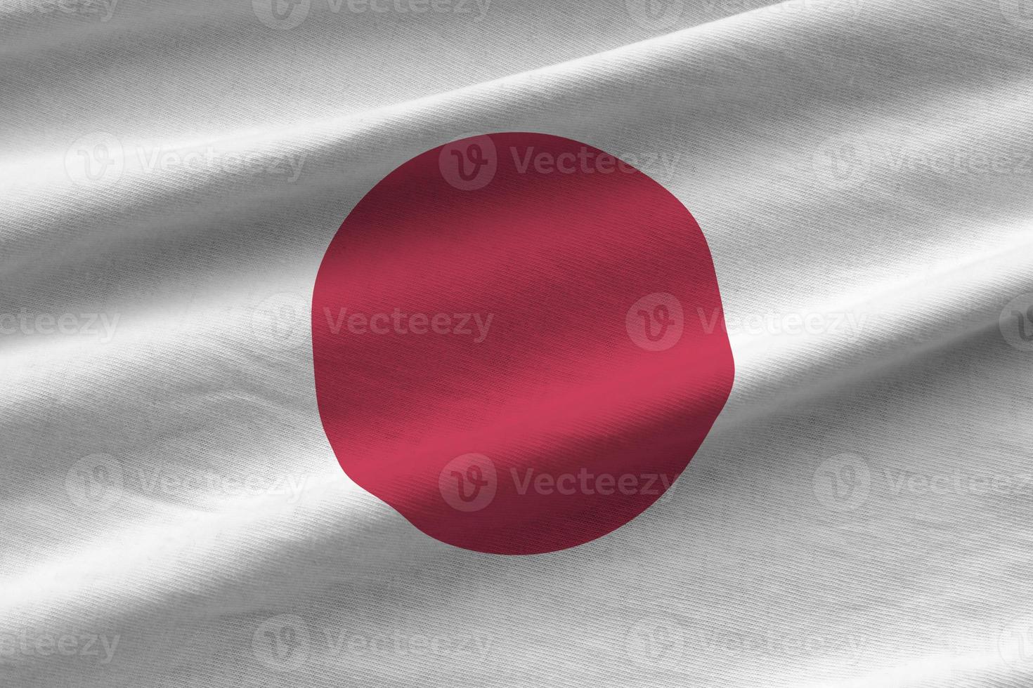 Giappone bandiera con grande pieghe agitando vicino su sotto il studio leggero al chiuso. il ufficiale simboli e colori nel bandiera foto